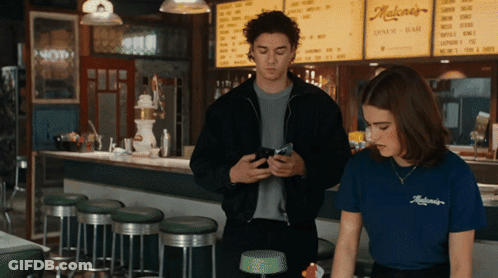 Man And Woman In Front Of Maloney's Diner Bar GIF