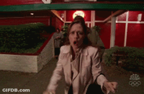 Man And Woman In Front Of Red NBC Building GIF