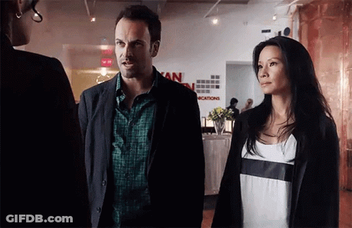 Man And Woman In Front Of Vacations Sign GIF