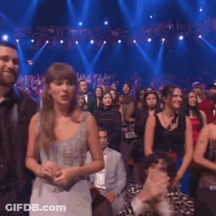 Man And Woman In Headphones With New Heights Sign GIF