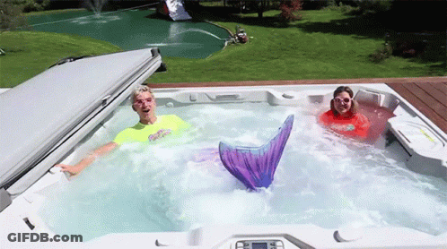 Man And Woman In Hot Tub With Mermaid Tail GIF