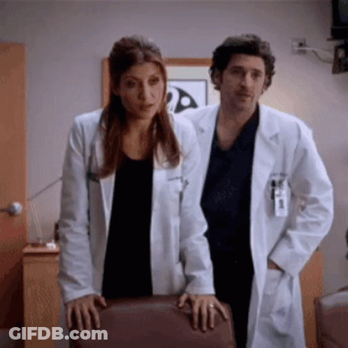 Man And Woman In Lab Coats Standing Together GIF