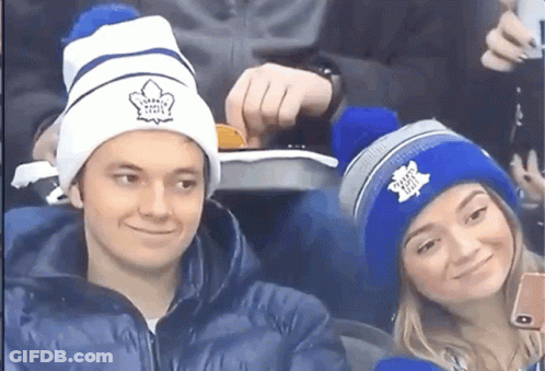 Man And Woman In Maple Leaf Beanies GIF