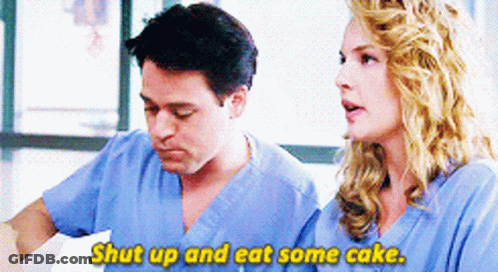 Man And Woman In Scrubs Talking Woman Says Shut Up And Eat Some Cake GIF
