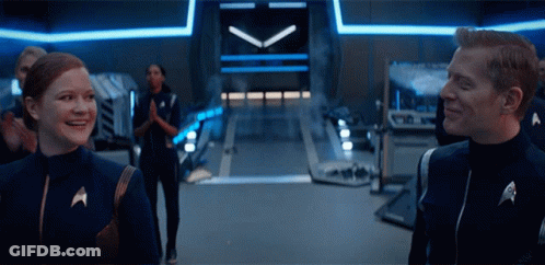 Man And Woman In Star Trek Uniforms Smiling GIF