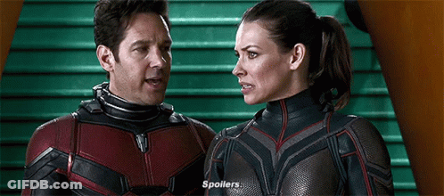 Man And Woman In Superhero Costumes Standing And Talking GIF