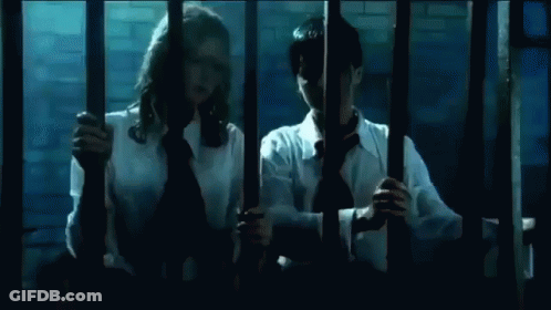Man And Woman Kissing Behind Bars GIF