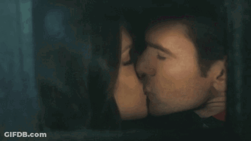 Man And Woman Kissing Behind Window GIF