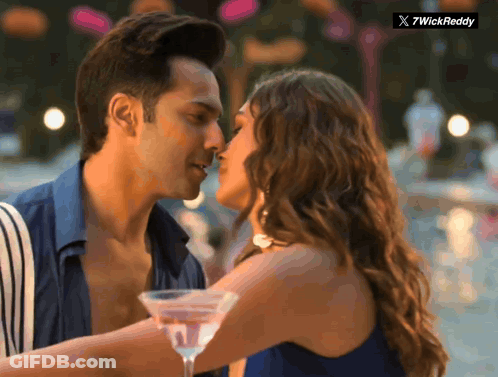 Man And Woman Kissing In Front Of 7Wickreddy Logo GIF