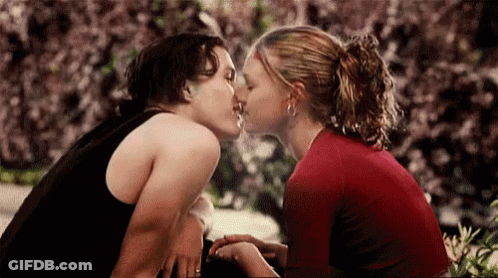 Man And Woman Kissing In Front Of Bush GIF