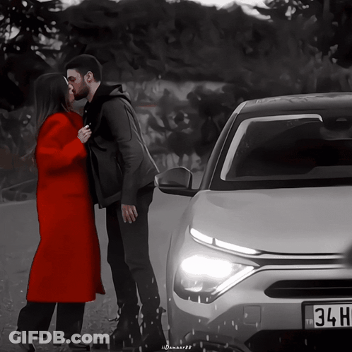 Man And Woman Kissing In Front Of Car With 34H License Plate GIF