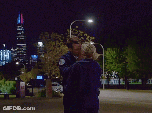 Man And Woman Kissing In Front Of City Skyline At Night GIF