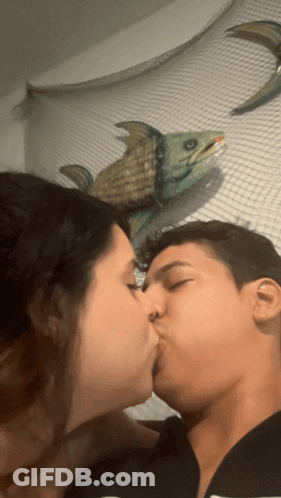 Man And Woman Kissing In Front Of Fish GIF