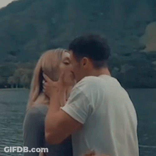 Man And Woman Kissing In Front Of Lake GIF