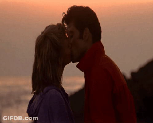 Man And Woman Kissing In Front Of Ocean GIF