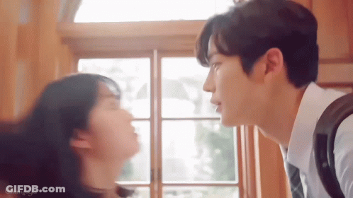 Man And Woman Kissing In Front Of Window GIF