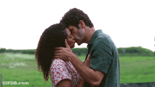 Man And Woman Kissing In Green Field GIF