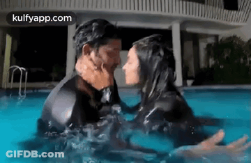 Man And Woman Kissing In Swimming Pool At Night GIF
