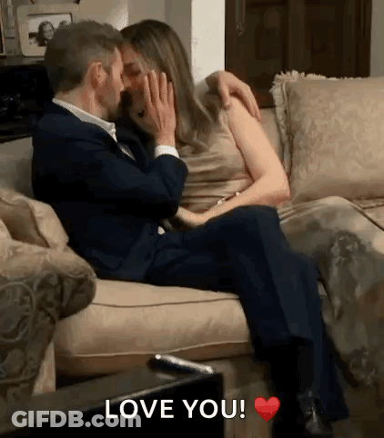 Man And Woman Kissing On Couch Saying Love You GIF