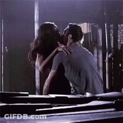 Man And Woman Kissing On Table In Dark Room GIF