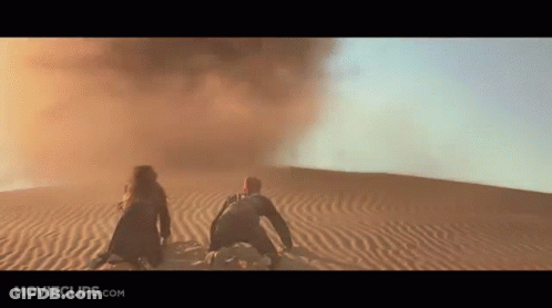 Man And Woman Kneeling In Desert Sand GIF
