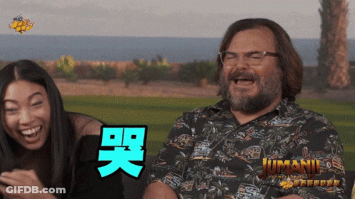 Man And Woman Laughing In Front Of Jumani Poster GIF
