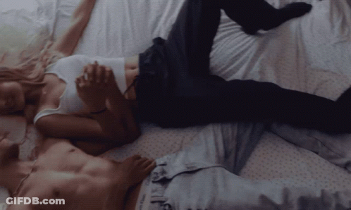 Man And Woman Laying On Bed Holding Hands GIF