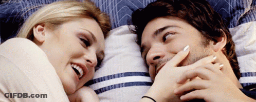 Man And Woman Laying On Bed Smiling GIF