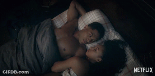 Man And Woman Laying On Bed With Netflix Logo GIF