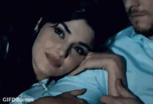 Man And Woman Laying On Couch Woman Looking At Camera GIF