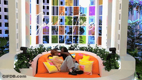 Man And Woman Laying On Round Couch With Love Window GIF