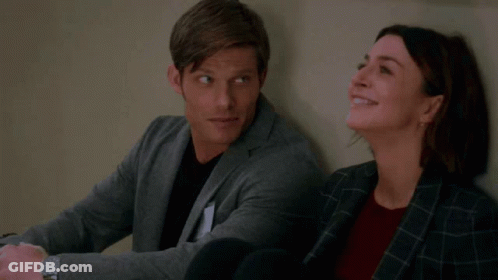 Man And Woman Leaning Against Wall Smiling GIF