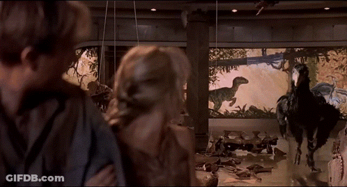 Man And Woman Looking At Dinosaur Display GIF