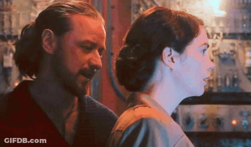 Man And Woman Looking At Each Other In Dark Room GIF