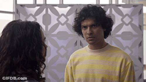 Man And Woman Looking At Each Other, Man In Yellow And Pink Striped Shirt GIF