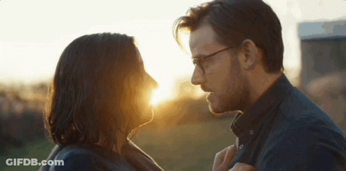 Man And Woman Looking At Each Other With Sun Shining Through Eyes GIF