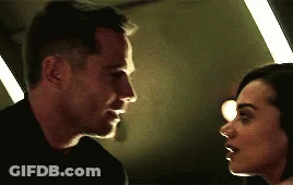 Man And Woman Looking Into Each Other's Eyes In Dark Room GIF