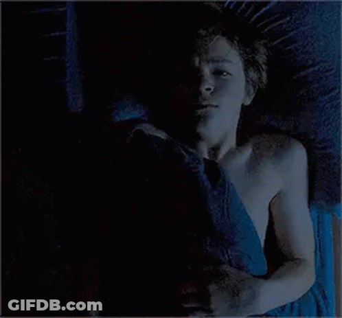 Man And Woman Lying On Bed Holding Hands GIF