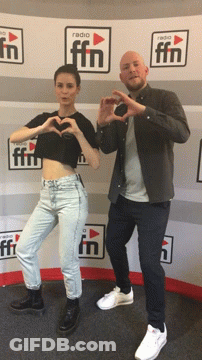 Man And Woman Making Hearts In Front Of Radio FM Wall GIF