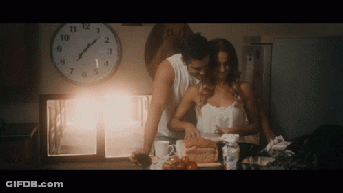 Man And Woman Near Clock Showing Almost 5 GIF