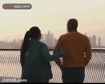 Man And Woman On Bridge Overlooking City GIF