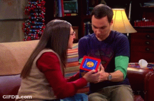 Man And Woman On Couch Man Holding Cube With Smiley Face GIF