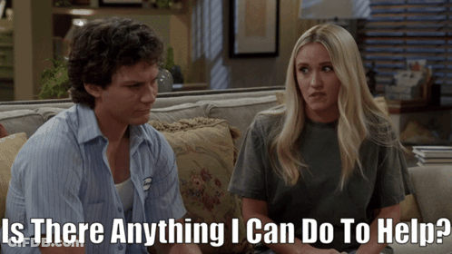 Man And Woman On Couch Saying Is There Anything I Can Do To Help GIF