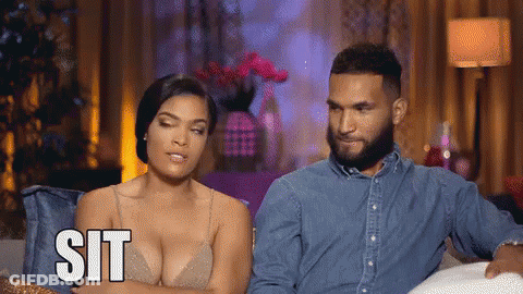 Man And Woman On Couch Woman Saying Sit GIF