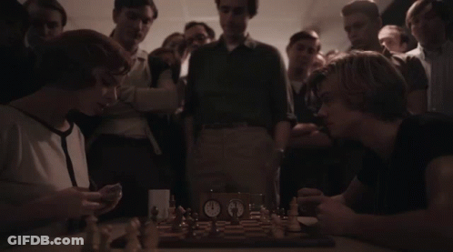 Man And Woman Playing Chess With Crowd Watching GIF