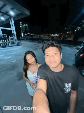 Man And Woman Posing For Selfie At Gas Station GIF