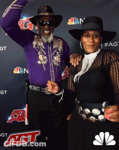 Man And Woman Posing In Front Of NBC Logo GIF