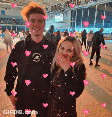 Man And Woman Posing With Pink Hearts GIF