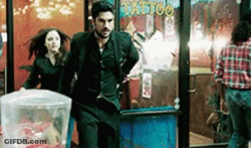 Man And Woman Running From Tattoo Shop GIF