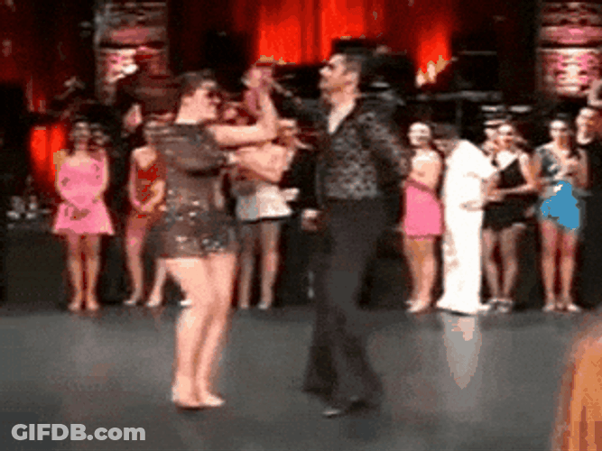Man And Woman Salsa Dancing With People Around GIF